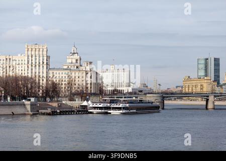 Mosca, Russia - 13 marzo 2022: Vista sul fiume di edifici moderni e storici lungo la Moscova con barche ormeggiate sul lungofiume Foto Stock