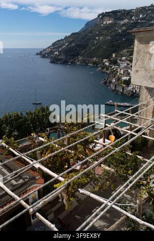 Una pergola sul tetto con vegetazione si affaccia su un bellissimo paesaggio costiero della Costiera Amalfitana in Italia. Foto Stock