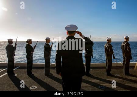 I marinai della Marina degli Stati Uniti si preparano a eseguire un saluto in tre salve durante una cerimonia di sepoltura in mare su un ascensore per aerei della portaerei di classe Nimitz USS Abraham Lincoln (CVN 72) il 23 novembre 2025. USS Abraham Lincoln (CVN 72), nave ammiraglia del gruppo di strike anfibio Abraham Lincoln, è in navigazione per operazioni di routine nell'area di operazioni della 3a flotta degli Stati Uniti, dimostrando l'impegno a lungo termine della Marina degli Stati Uniti per un Indo-Pacifico libero e aperto. (Foto della Marina degli Stati Uniti di Mass Communication Specialist Seaman Shepard Fosdyke-Jackson) Foto Stock