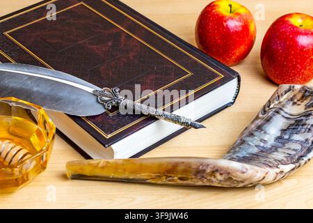Simboli di Rosh Hashanah tra cui un libro della Torah, una penna d'oca, miele, mele e uno shofar Foto Stock