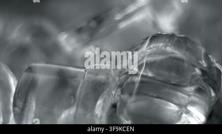 Cubetti di ghiaccio che galleggiano nell'acqua, mostrando forme astratte, texture e una trasparenza fresca e rinfrescante Foto Stock