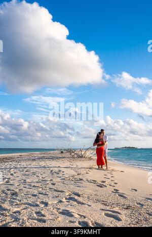 Coppia in piedi su una banchina di sabbia in una spiaggia delle Maldive Foto Stock