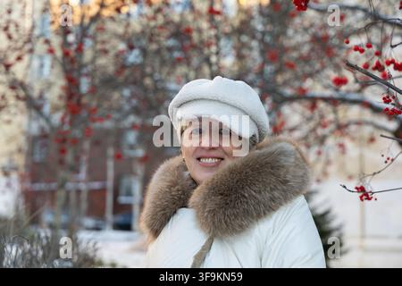 Ritratto ravvicinato di una bella donna matura dal fascino senza tempo che sorride alla macchina fotografica in una giornata invernale soleggiata nell'Europa del Nord Foto Stock