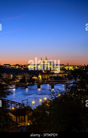 Città di Praga al crepuscolo nella Repubblica Ceca. Vista sul Castello di Praga e sul fiume Vltava di sera dal punto di vista di Vysehrad. Foto Stock
