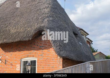 Cottage tradizionale inglese in mattoni con un dettaglio architettonico di tetto di paglia spesso Foto Stock