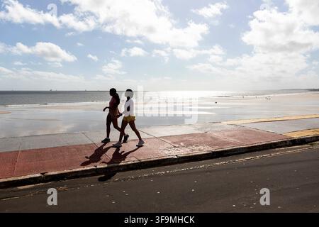 Due donne locali durante una passeggiata mattutina di fitness lungo la spiaggia sabbiosa dell'Oceano Atlantico nella città costiera di Sao Luis, regione di Maranhao, Brasile. Foto Stock