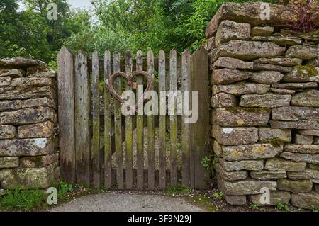 Bibury, Inghilterra, 03 giugno 2018 - Piccolo cancello da giardino in legno con un affascinante decoro a forma di cuore. Foto Stock