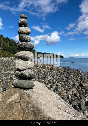 Un cumulo di pietre accuratamente bilanciato si trova su una spiaggia di ciottoli rocciosi nel Seal Bay Nature Park sull'isola di Vancouver, Columbia Britannica, Canada. Foto Stock
