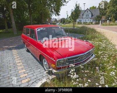 Automobile classica rossa parcheggiata accanto a un prato fiorito in un'area di villaggio, automobile classica, Audi F103 Variant, Ilsede, distretto di Peine, Bassa Sassonia, Germania Foto Stock