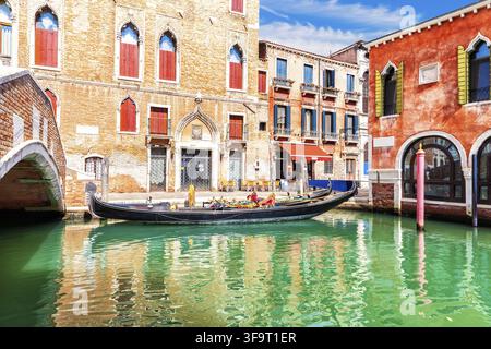 Tradizionale gondola vicino al ponte vicino al tipico palazzo di Venezia Foto Stock