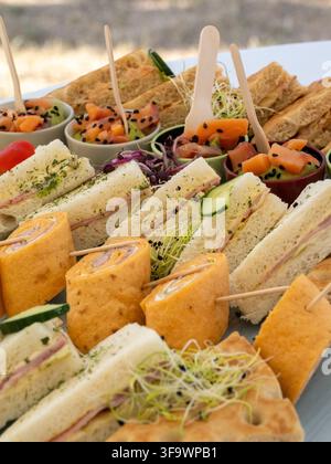 Sandwich assortiti e coppette di verdure serviti come antipasti su un tavolo. Foto Stock