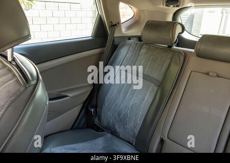 Ampia prospettiva interna dei sedili posteriori passeggero con coprisedili grigi, poggiatesta e finestrini laterali di un SUV. Foto Stock