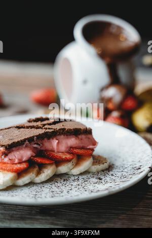 Pancake al cioccolato con crema alle fragole e fette di banana Foto Stock