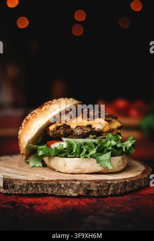 Cheeseburger gourmet su una fetta di legno rustico Foto Stock