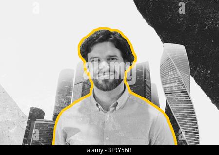 Giovane uomo caucasico sorridente in abito da lavoro in piedi davanti a grattacieli urbani, concetto di business Foto Stock