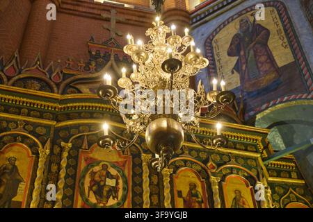 Lampadario ornato che illumina un interno di chiesa ortodossa riccamente decorato con iconografia religiosa nella Cattedrale di San Basilio - Mosca, Russia, agosto Foto Stock