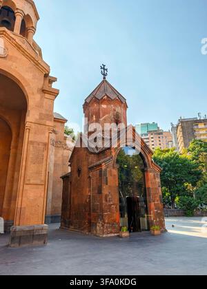Chiesa di Santa Anna con arco in pietra rossa. La torre si erge sopra l'ingresso ad arco. Cielo blu chiaro sopra la struttura in pietra. Edifici urbani visibili sullo sfondo Foto Stock