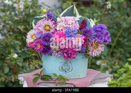Composizione floreale di aster cinesi rosa e viola, rosa, anemoni giapponesi, dalie, fiori di ortensia, fiori di cespuglio farfalla e foglie di hosta Foto Stock