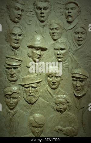 Scultura in bassorilievo che raffigura emigranti irlandesi all'Ulster American Folk Park vicino a Omagh, Contea di Tyrone, Irlanda del Nord. Foto Stock
