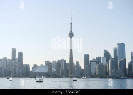 Lo skyline di Toronto è visto dall'acqua al tramonto, con l'iconica Torre CN, il Rogers Centre e i grattacieli moderni. Diversi sai Foto Stock