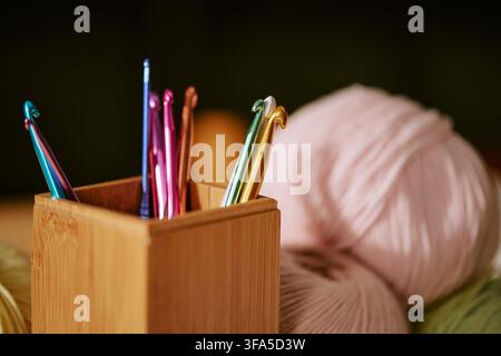 Ganci per uncinetto in portacorda di legno con palline di filo per workshop di uncinetto Foto Stock