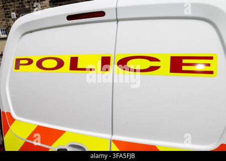 Primo piano delle porte posteriori di un furgone della polizia britannica bianco con grandi scritte rosse della polizia su pannelli gialli fluorescenti con alta visibilità rosso a Foto Stock