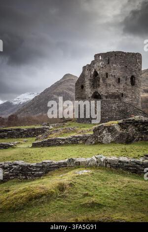 Le rovine storiche del Dolbadarn Castle Tower a Llanberis, Parco Nazionale di Eryri (Snowdonia), nel Galles del Nord, sotto nuvole di tempesta scure e drammatiche. Dritto. Foto Stock