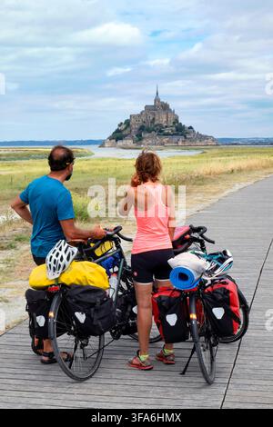 Coppia con biciclette cariche, Baia di Mont-Saint-Michel, Normandia, Francia, Europa Foto Stock