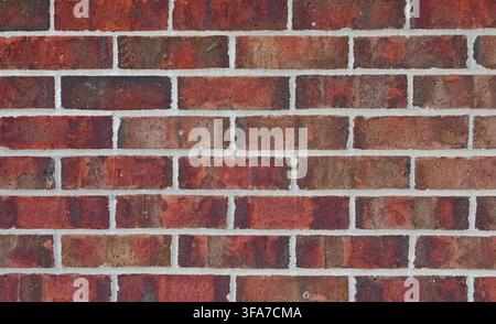 Primo piano orizzontale di una superficie di muro in mattoni rossi morbidi e malta con aspetto acquerellato, mattoni ruvidi e irregolari, malta porosa Foto Stock