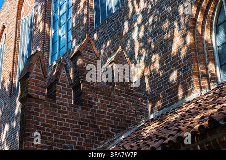 Una vista ravvicinata della facciata in mattoni della chiesa di Saint James mostra archi appuntiti, finestre alte e strette e dettagli gotici decorativi. Foto Stock