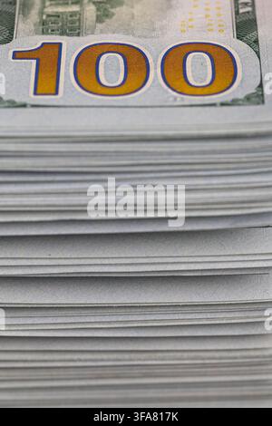 Macro close-up di una pila di cento banconote da un dollaro USA che mostra il grande numero dorato 100 Foto Stock