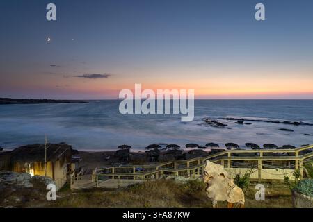 Resort di Ayfilon al crepuscolo, cielo sfumato vivace al tramonto e una falce di luna con una stella luminosa sopra. Cipro del Nord. Dipkarpaz Foto Stock