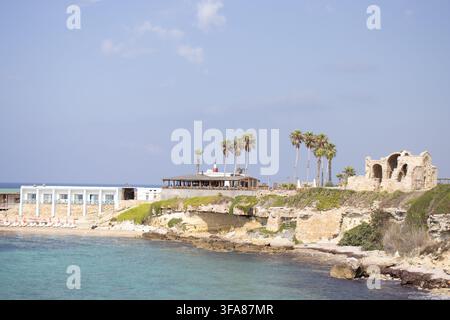 Hotel e ristorante Oasis sulla spiaggia di Ayfilon. Dipkarpaz. Vista costiera sulle rovine storiche in pietra, resort sul lungomare. Foto Stock