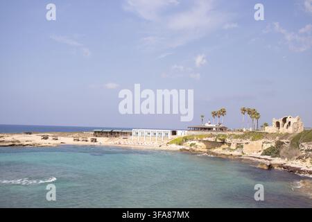 Hotel e ristorante Oasis sulla spiaggia di Ayfilon. Dipkarpaz. Vista costiera sulle rovine storiche in pietra, resort sul lungomare. Foto Stock