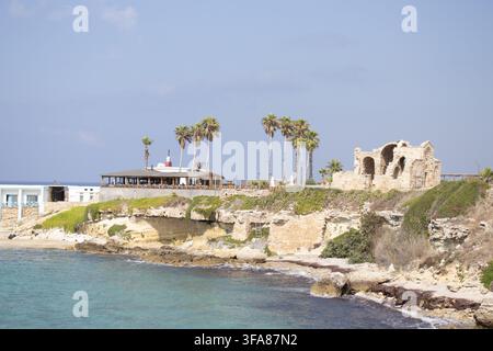 Hotel e ristorante Oasis sulla spiaggia di Ayfilon. Dipkarpaz. Vista costiera sulle rovine storiche in pietra, resort sul lungomare. Foto Stock