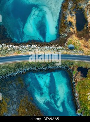 Veduta aerea di una strada asfaltata sopra l'acqua turchese dell'oceano Foto Stock