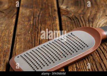 Utensile da cucina e preparazione culinaria, primo piano di una grattugia di metallo su un tavolo di legno rustico, preparazione di cibi e strumenti culinari Foto Stock