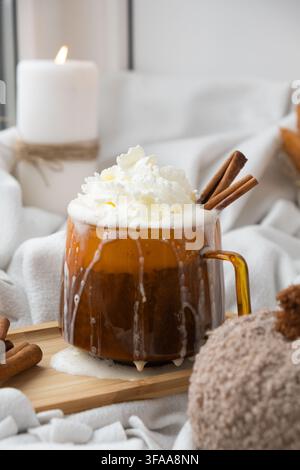 Latte speziato di zucca per riscaldare il caffè al mattino. Bevande autunnali per Halloween, giorno del Ringraziamento, bevanda autunnale piccante alla cannella, bevande calde di stagione in un'accogliente tazza d'arancia. Atmosfera di fredde giornate piovose natura morta Foto Stock