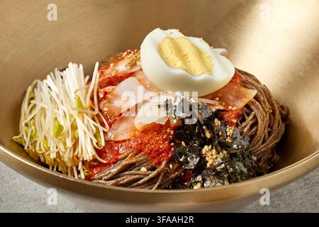 Pasto completo tradizionale coreano con stufato di pasta di fagioli neri Doenjang Jjigae, riso e assortiti piatti di accompagnamento Banchan in ciotole dorate su un vassoio di legno, Cor Foto Stock