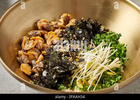 Pasto completo tradizionale coreano con stufato di pasta di fagioli neri Doenjang Jjigae, riso e assortiti piatti di accompagnamento Banchan in ciotole dorate su un vassoio di legno, Cor Foto Stock