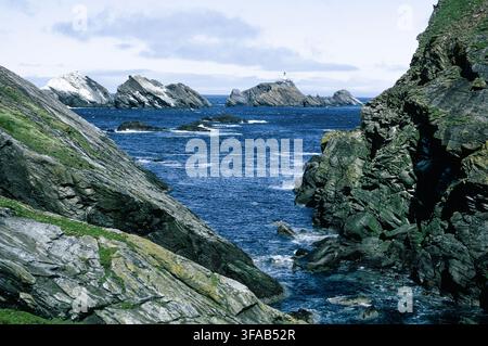 Faro di Muckle Flugga e scogliere frastagliate da Hermaness, Unst, Isole Shetland, Scozia. Foto Stock