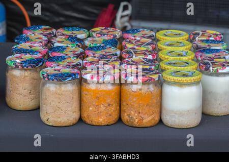 Vari prodotti alimentari fatti in casa in barattoli esposti su un banco del mercato. Foto Stock