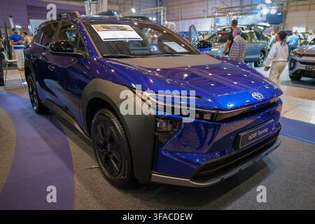 Lisbona, Portogallo - 16 maggio 2026: SUV elettrico blu Toyota bZ4X Touring esposto al salone automobilistico ECAR Show, con visitatori e cartello dell'evento visibile Foto Stock
