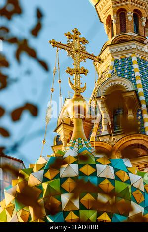 Le cupole dorate della cattedrale Salvato dal Sangue attraverso il fogliame giallo e i cancelli in ferro battuto del giardino Mikhailovsky in una giornata autunnale soleggiata Foto Stock