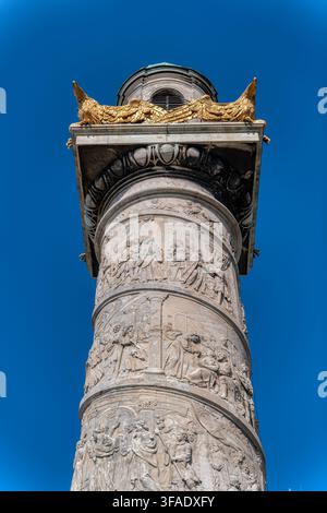 Colonna a rilievo scolpita della Karlskirche con aquila dorata contro il cielo blu a Vienna Foto Stock