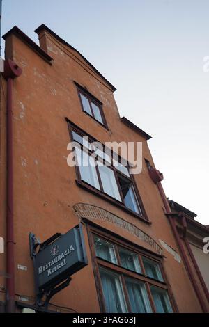 Guarda verso la facciata logorata a ocra arancione dell'edificio storico che ospita la "Restauracja Kubicki", il più antico ristorante della Polonia a Danzica, Polonia. Foto Stock