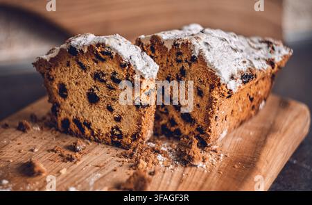 Torta margherita con gocce di cioccolato spolverata di zucchero a velo su una tavola di legno con briciole Foto Stock