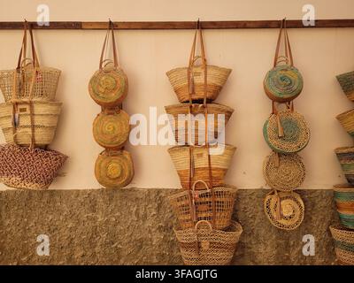 Borse tradizionali in paglia intrecciata appese al muro nel mercato di Santanyí a Maiorca, Spagna Foto Stock