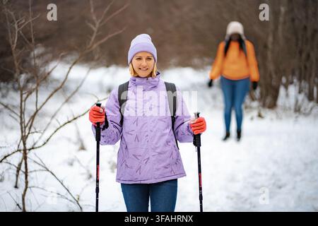 Due amiche che camminano su un sentiero innevato in inverno Foto Stock