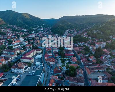 Vista aerea panoramica del centro storico di Brasov con la Chiesa Nera, tetti dalle tegole rosse e colline circostanti in Transilvania, Romania. Foto Stock
